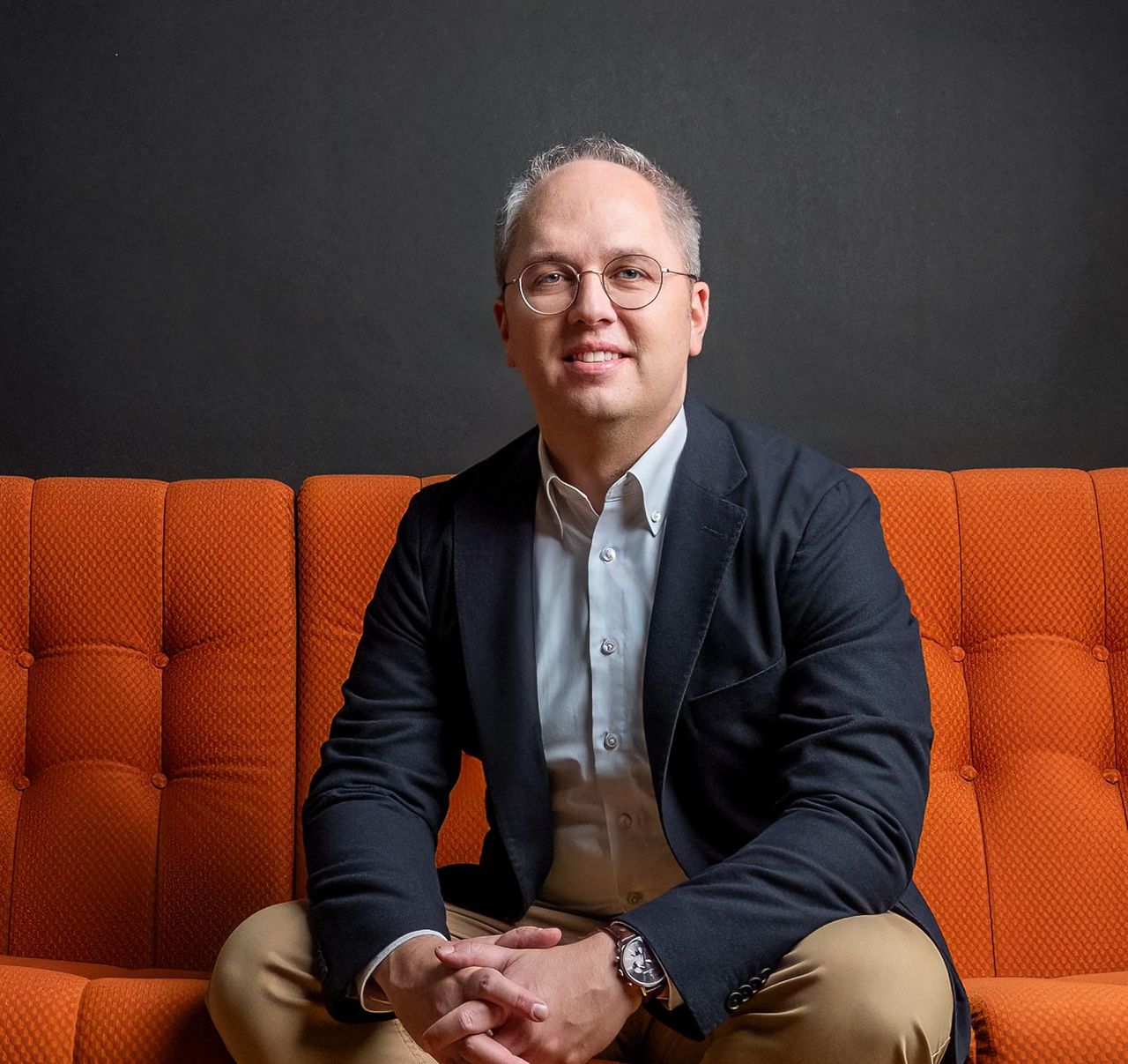 CEO Jens Meier der Stadtwerke Lübeck Gruppe sitzt auf einem orangenen Sofa