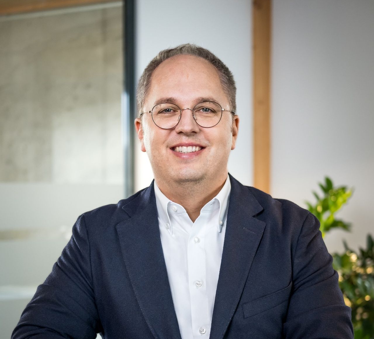 CEO Jens Meier lehnt an einem Tresen und lächelt in die Kamera
