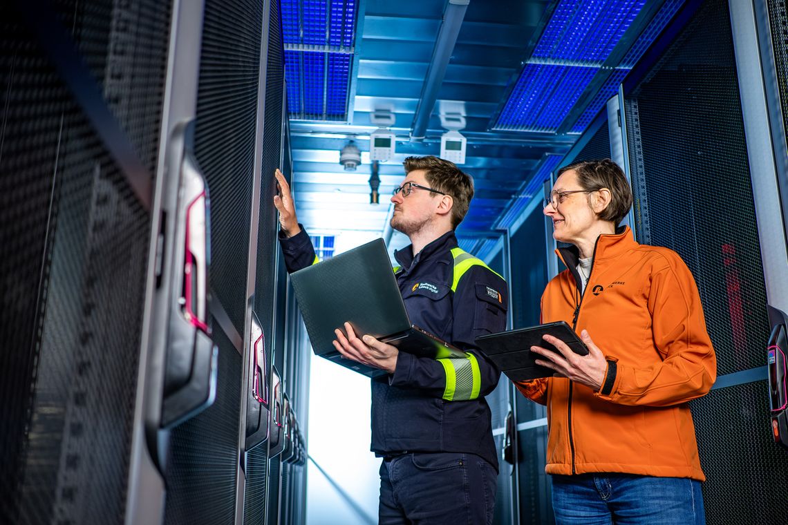 Techniker und Leiterin prüfen Server im Rechenzentrum