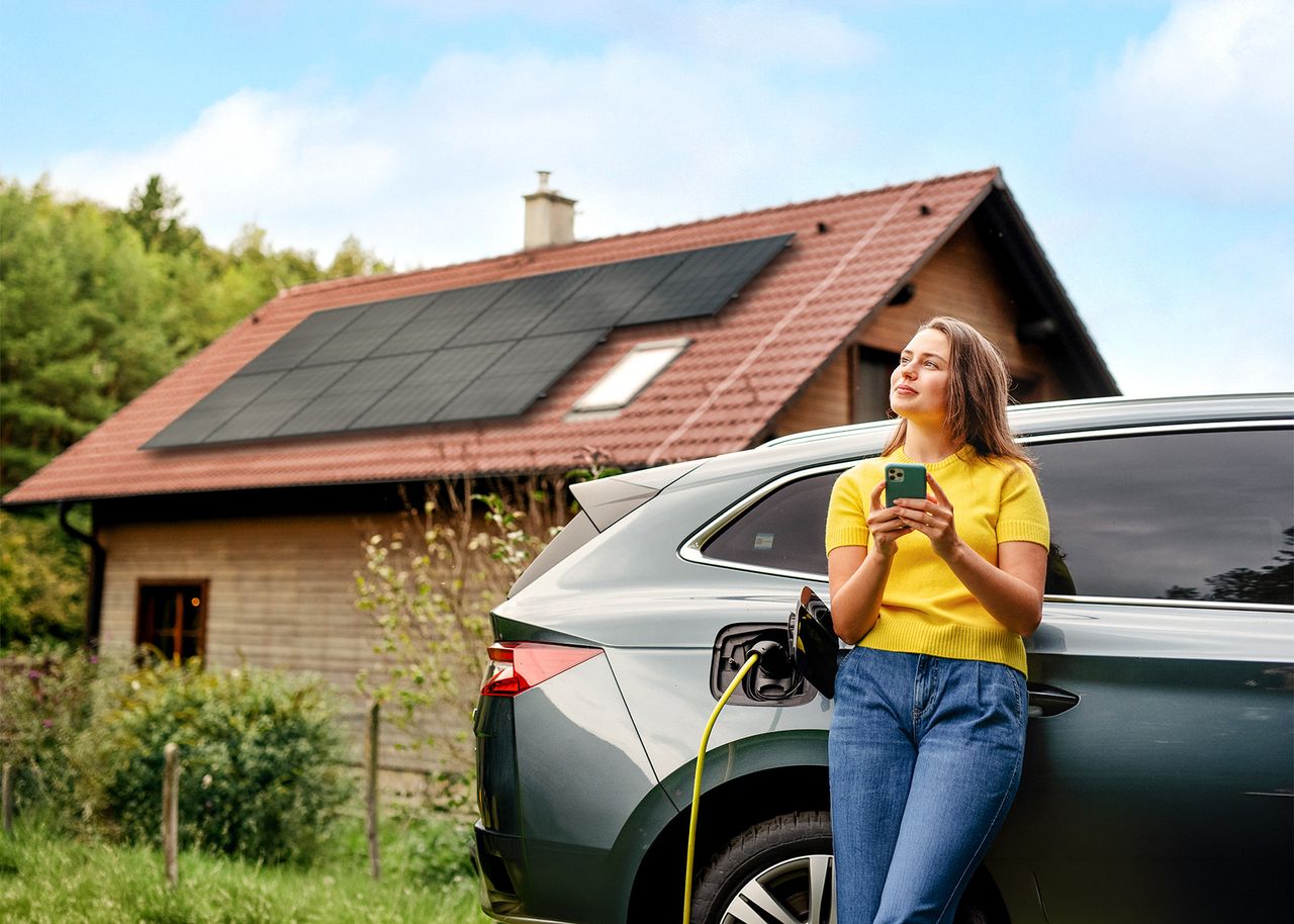 Frau lädt E-Auto mit Solarstrom