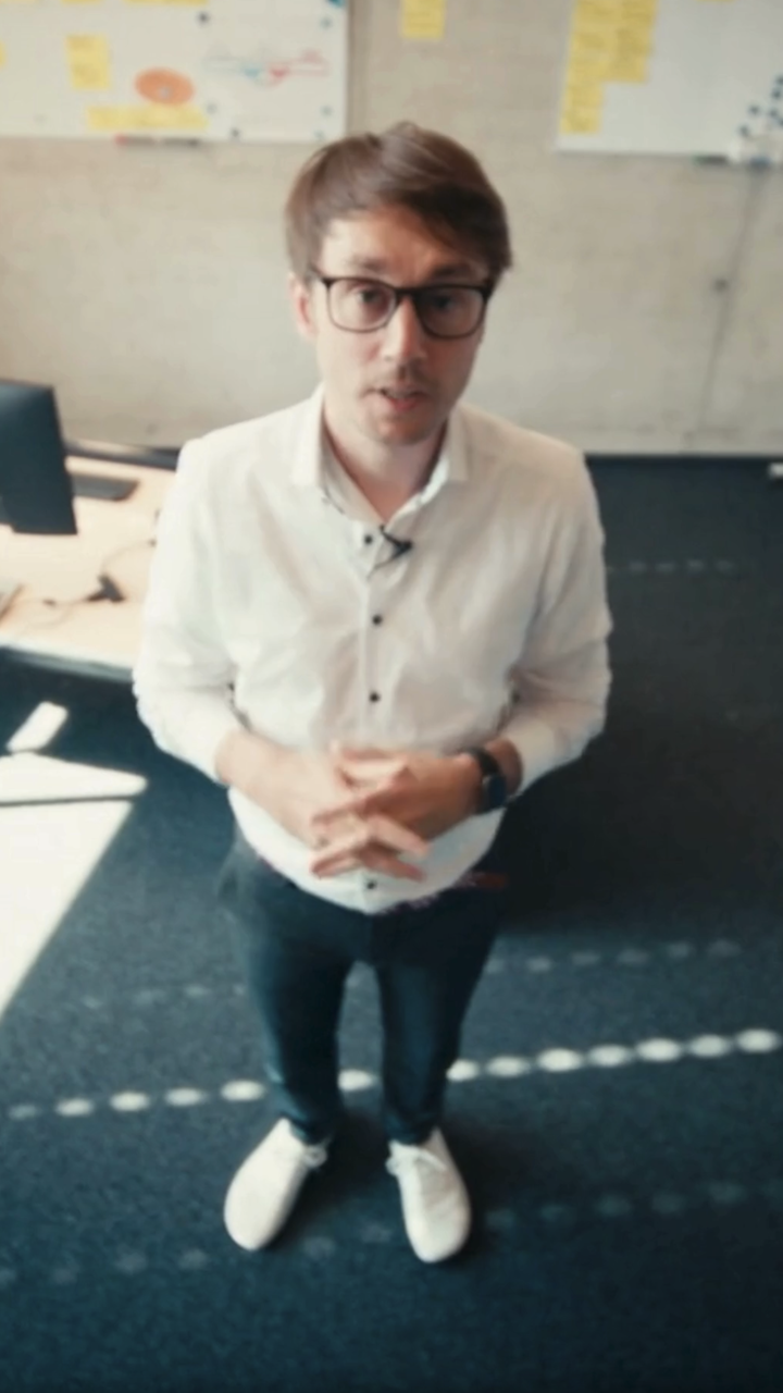 Mann steht in Büro und erklärt