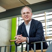 CEO Jens Meier lehnt an Geländer und lächelt in die Kamera
