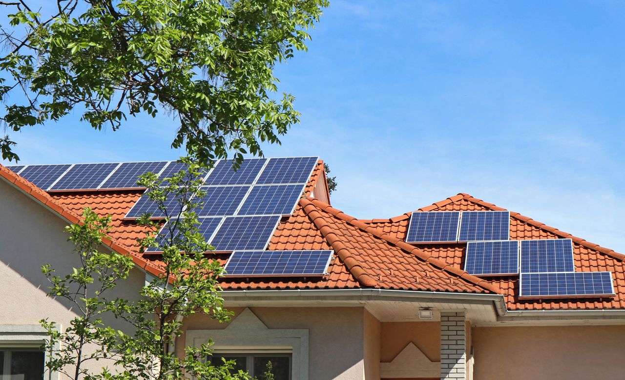 Haus mit roten Dachziegeln und PV-Anlagen