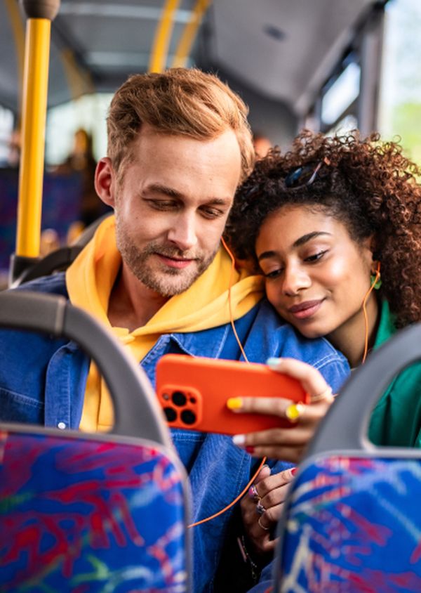 Pärchen im Bus, schaut Video auf Handy