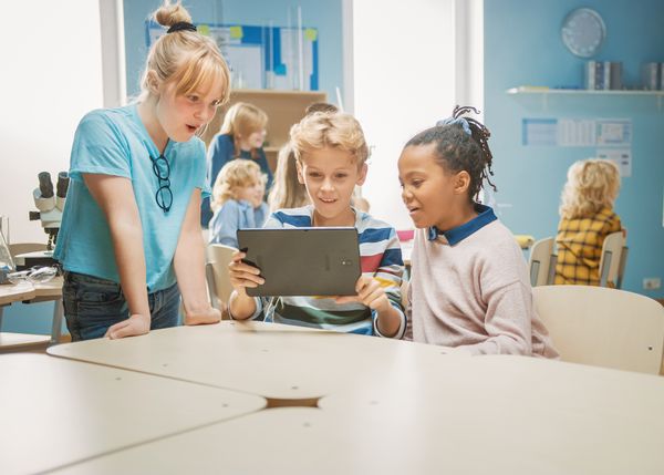 Kinder vor Tablet, sitzend im Klassenzimmer