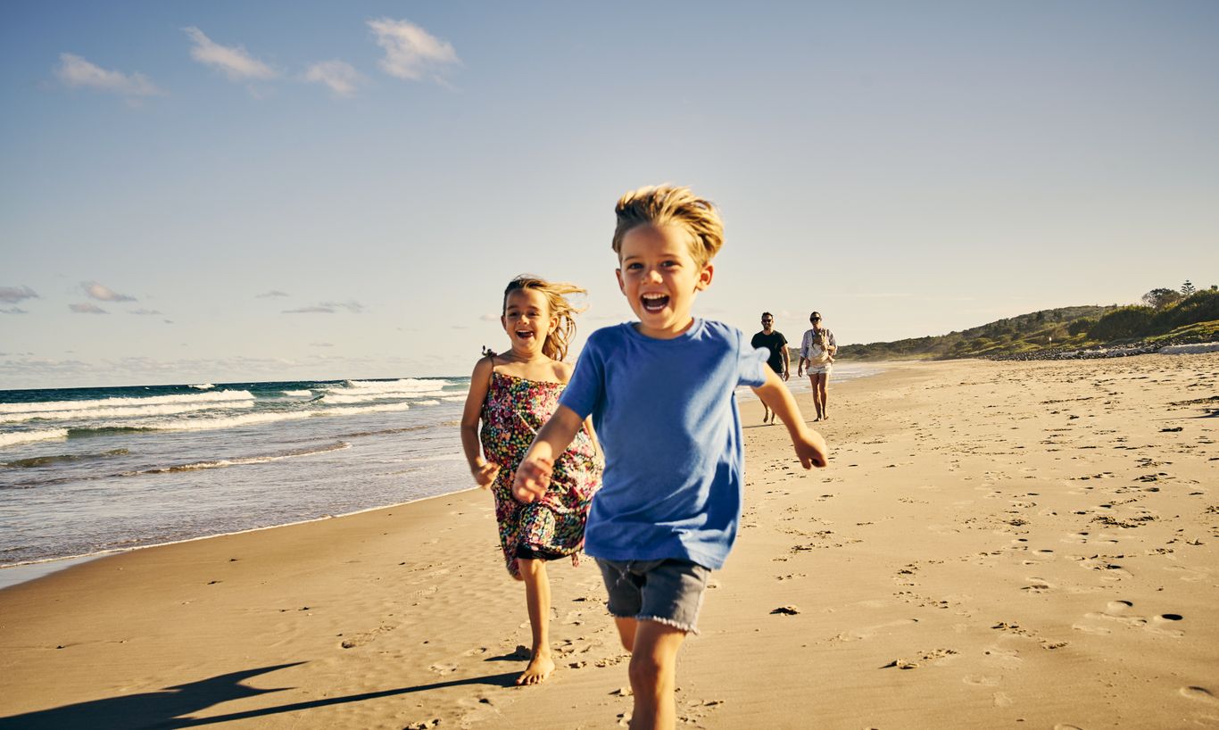 Kinder die am Strand laufen